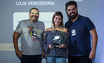 Gerson Ribeiro da Vitrio entregando o prêmio para Rafael Montalvao e Andrea Josefic da Magazine Luiza